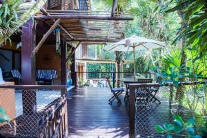 an outdoor patio with a table and an umbrella at CASA DA ILHA em CONDOMINIO in Ilhabela