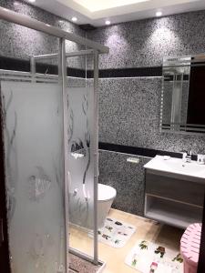 a bathroom with a shower and a toilet and a sink at Bright Get Away Condo in Sharm El Sheikh