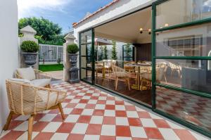 un patio con sillas y mesas en un suelo a cuadros en BCascais Boutique House by APT IIN en Cascais