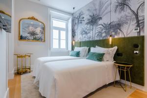 two beds in a white room with a mural on the wall at BCascais Boutique House by APT IIN Cascais Center in Cascais