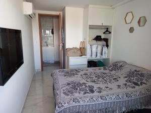 a bedroom with a bed and a flat screen tv at Apartamento Encantador - MAKAMBIRA RESIDENCE in Porto De Galinhas