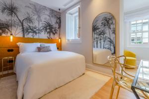 a bedroom with a large bed and a chair at BCascais Boutique House by APT IIN Cascais Center in Cascais