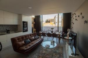 Una sala de estar con un sofá de cuero y una mesa. en Birds Apartments, en Oporto