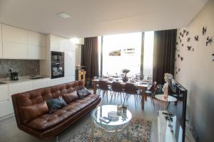 a living room with a brown leather couch and a table at Birds Apartments Porto by Wonderexperience in Porto