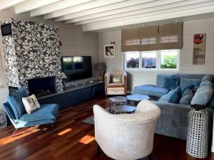 a living room with a blue couch and chairs at grande villa familiale in Saint-Pair-sur-Mer