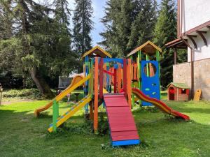un parque infantil con un colorido tobogán en el césped en Апартамент Горска приказка - Forest tale en Smolyan