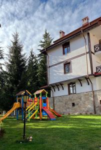 un parque infantil en un patio junto a un edificio en Апартамент Горска приказка - Forest tale en Smolyan