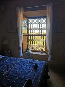 a bedroom with a bed and a window at Maison d'hôtes IZZA in Kalaat MGouna