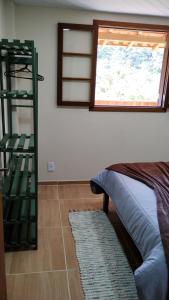 Habitación con cama, ventana y escalera. en Casa Verde da Floresta da Gávea, en Visconde De Maua