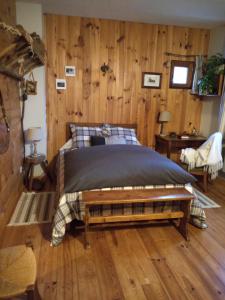 a bedroom with a bed with a wooden wall at La Grande Ourse in Campan