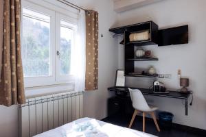 una camera da letto con scrivania, finestra e sedia di A Casa Di Grazia a Ragusa
