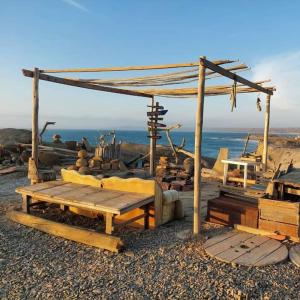 a wooden picnic table and bench on the beach at La Casa del Naufrago in Lobitos +20 photos