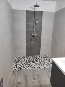 a bathroom with a shower with a tile floor at Villa NoAmy in Les Anses-dʼArlets