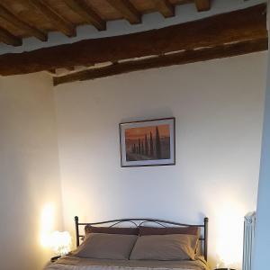 una camera con un letto e una foto appesa al muro di Appartamento Athena a Montepulciano