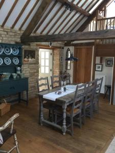 a dining room with a wooden table and chairs at 3 BEDROOM 5* BARN CONVERSION COTSWOLDS in Chipping Norton