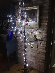 a christmas tree with lights in front of a fireplace at 3 BEDROOM 5* BARN CONVERSION COTSWOLDS in Chipping Norton
