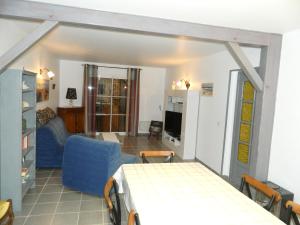 a living room with a blue couch and a table at Maison familiale spacieuse à Le Verdon-sur-Mer avec jardin 120 m² in Le Verdon-sur-Mer
