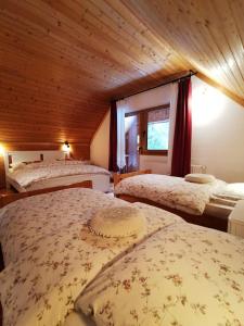 three beds in a room with a wooden ceiling at Chalet Via Mons in Mojstrana