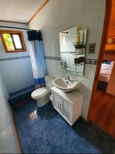 y baño con aseo, lavabo y espejo. en Cabañas Renacer en Casa Grande - Algarrobo, en Algarrobo