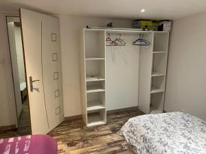 a bedroom with a bed and a closet with shelves at Bel appartement T3 proximité centre et commerces in Pélussin