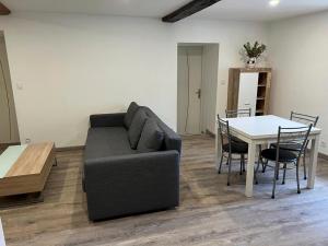 een woonkamer met een bank en een tafel bij Bel appartement T3 proximité centre et commerces in Pélussin