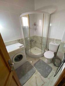een badkamer met een douche, een toilet en een wasmachine bij Sapanca voyage2 havuzlu müstakil villa in Sapanca