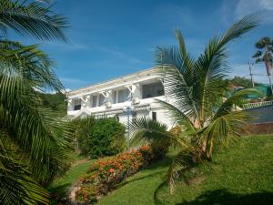 a white house with palm trees in front of it at Résidence Madicréoles in Le Carbet