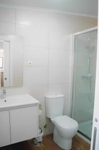 a bathroom with a toilet and a glass shower at Casa Bela Vista de Moledo in Moledo +33 photos