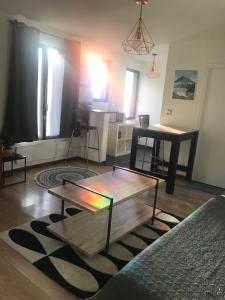 a living room with a coffee table and a kitchen at Studio 30m2 sympa à la limite de TOURS in Saint-Pierre-des-Corps