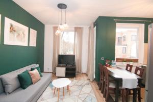 a living room with a couch and a dining room at DMK Green Apartment near Warsaw-Modlin Airport in Nowy Dwór Mazowiecki +19 photos