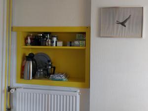 een keuken met een gele plank met een vogel erop bij Klein Ni'jenhoes in Winterswijk