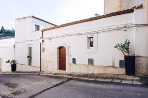 un edificio blanco con una puerta marrón en una calle en A Casa Di Grazia, en Ragusa