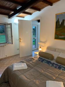 a bedroom with a large bed and a couch at Casetta degli Ulivi Maccarese in Le Cerquete