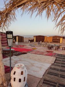 a room with tables and rugs and a parking meter at Tikida Camp by tinfou in Zagora