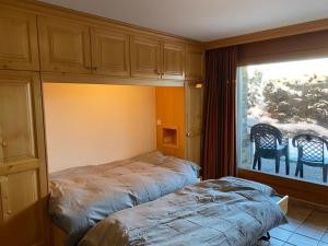 a bedroom with a bed and a large window at Garden Studio Apartment Crans Montana in Crans-Montana
