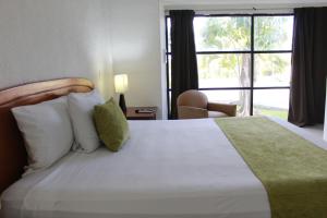 a bedroom with a large white bed with a window at Hotel Green 16 in Cancún