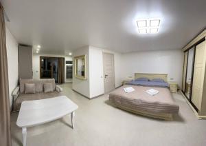 Un dormitorio con una cama, un sofá y una mesa. en Viktan Hotel, en Bukovel 60 fotos más