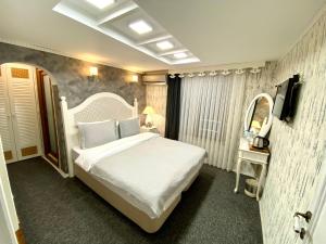 a bedroom with a white bed and a mirror at Peri Boutique Hotel in Sapanca