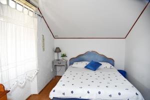 a bedroom with a bed with a blue headboard at Mansarda apartment in Kotor +7 photos