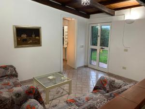 a living room with two couches and a table at Casetta degli Ulivi Maccarese in Le Cerquete