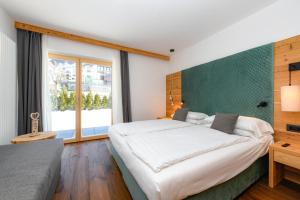a bedroom with a large bed and a large window at Bepy Hotel Garni in Giustino