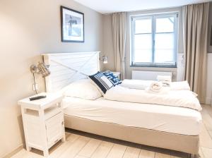 een kleine slaapkamer met een wit bed en een raam bij "Das Seehaus" by Lilianfeld Apartments in Allensbach