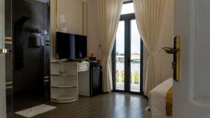 a hotel room with a television and a large window at Paradise Hotel & Homestay access alley 100m in Phu Yen
