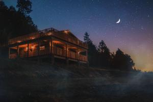 a cabin in the woods at night with a moon at Cabañas Agua del Oyamel in Perote
