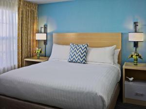 a bedroom with a large bed and a blue wall at Sonesta ES Suites Atlanta - Perimeter Center North in Atlanta