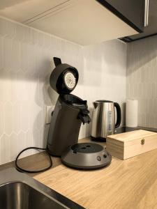 a kitchen counter with a coffee maker and a clock at APP202 Proche Disneyland Lagny sur Marne in Lagny