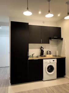 a kitchen with black cabinets and a washing machine at APP202 Proche Disneyland Lagny sur Marne in Lagny