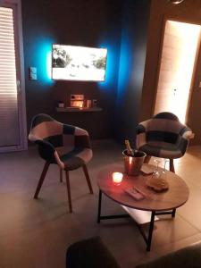 a living room with two chairs and a table at Le NaturOspa in Le Quesnoy-en-Artois
