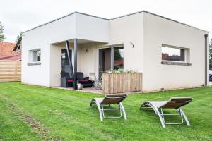 una casa blanca con 2 sillas en el patio en Le NaturOspa, en Le Quesnoy-en-Artois
