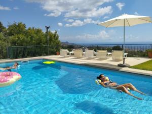 a woman laying on a raft in a swimming pool at Villa Capogrecale in Piedimonte Etneo